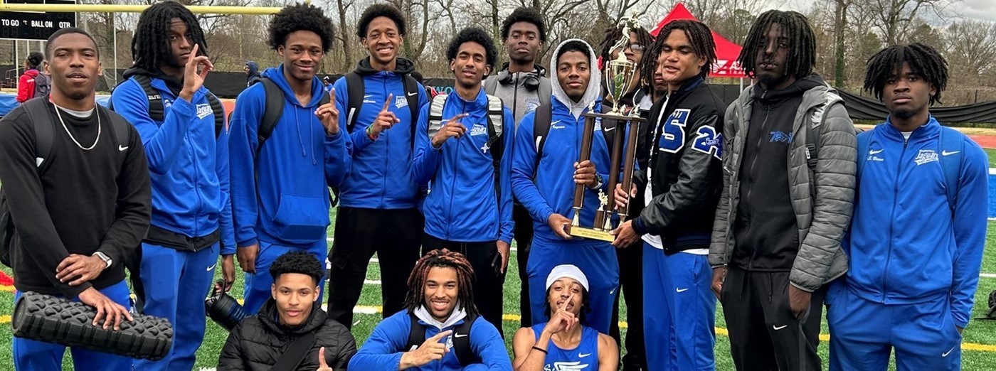 Track Boys holding a trophy celebrating a recent win at the track meet. 